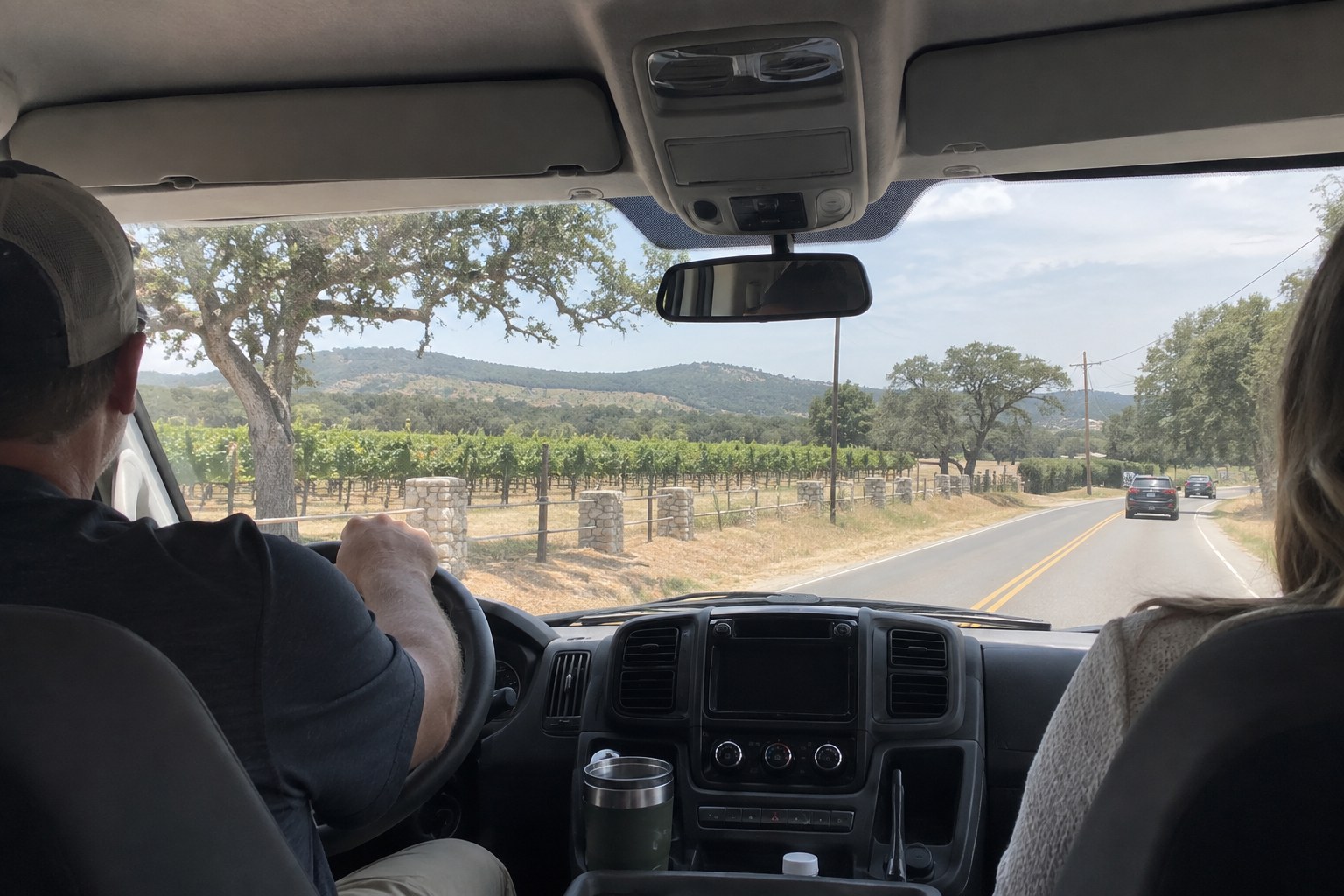 Shuttle van driving past vineyards on a Fredericksburg wine tour