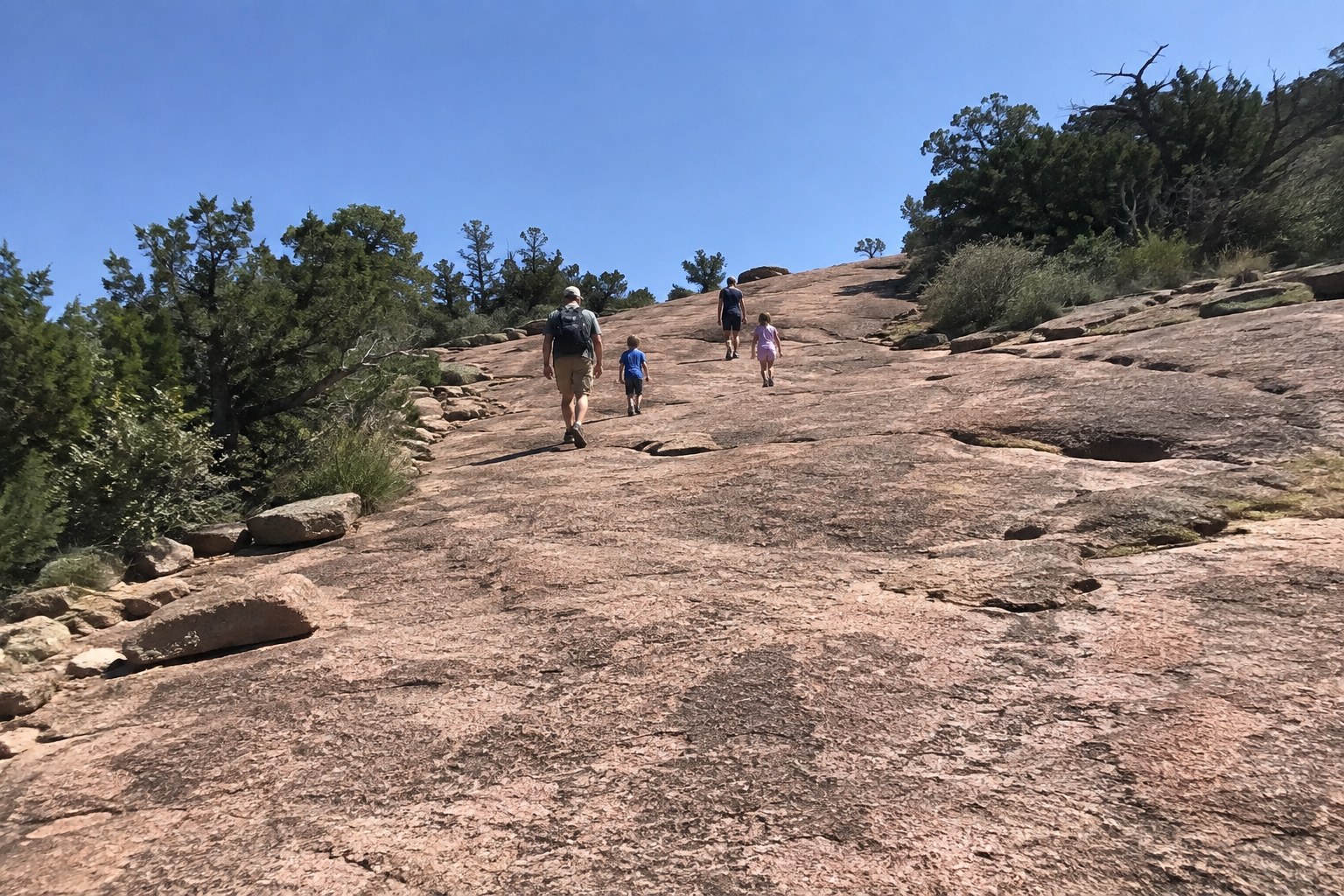 Family hiking the Summit Trail at Enchanted Rock near Fredericksburg